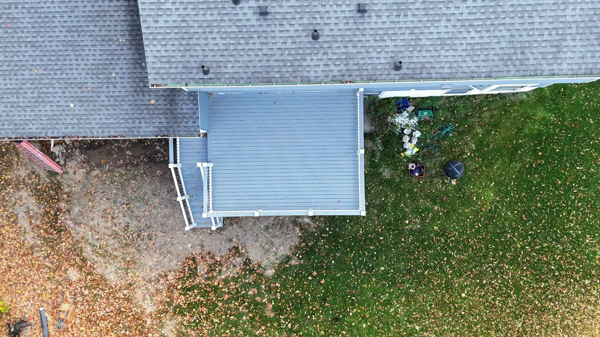 An aerial view of a house with a deck and a roof.