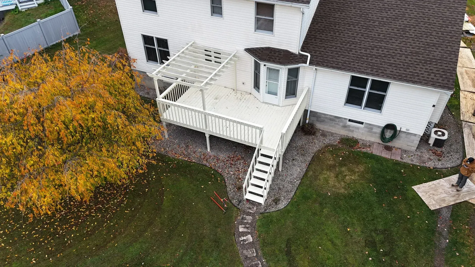 An aerial view of a house with a deck and a pergola.