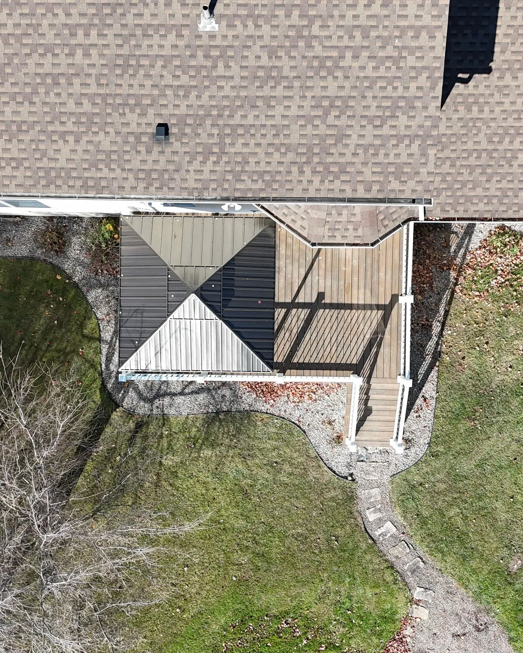 An aerial view of a house with a deck and a roof.