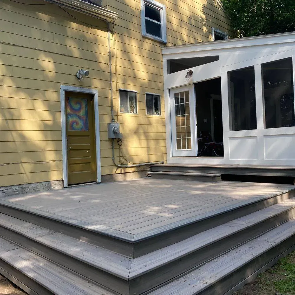 A yellow house with a deck in front of it