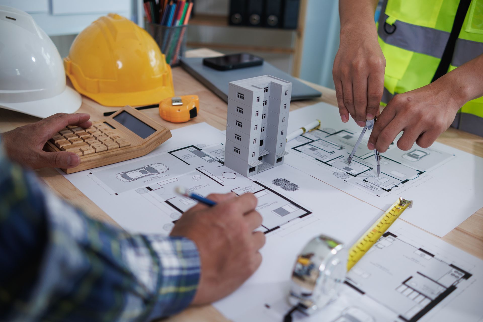 Deux ouvriers du bâtiment travaillent sur un plan d'un bâtiment.
