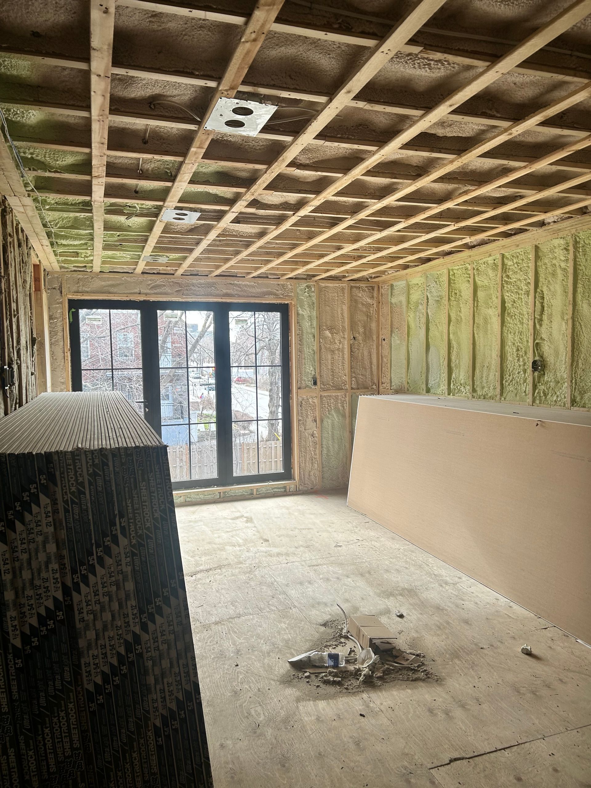 Une pièce en construction avec beaucoup d'isolation sur les murs et le plafond.