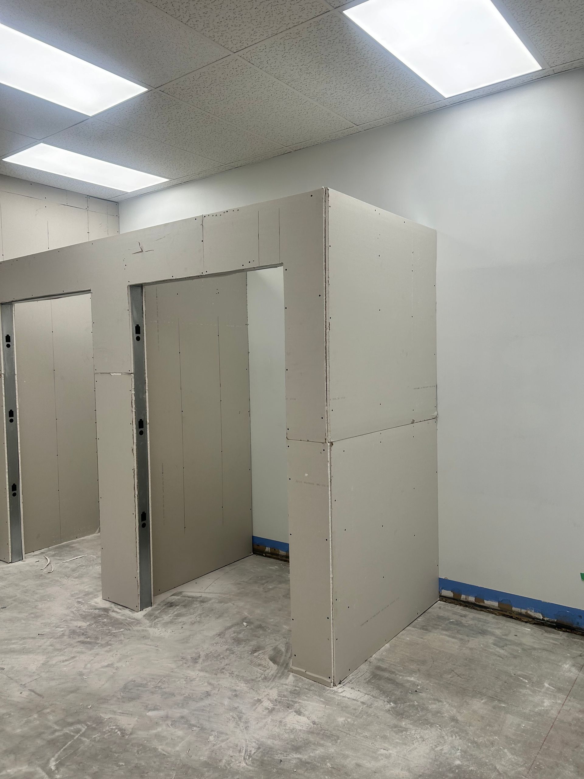 Une pièce avec beaucoup de murs en plaques de plâtre et un plafonnier.