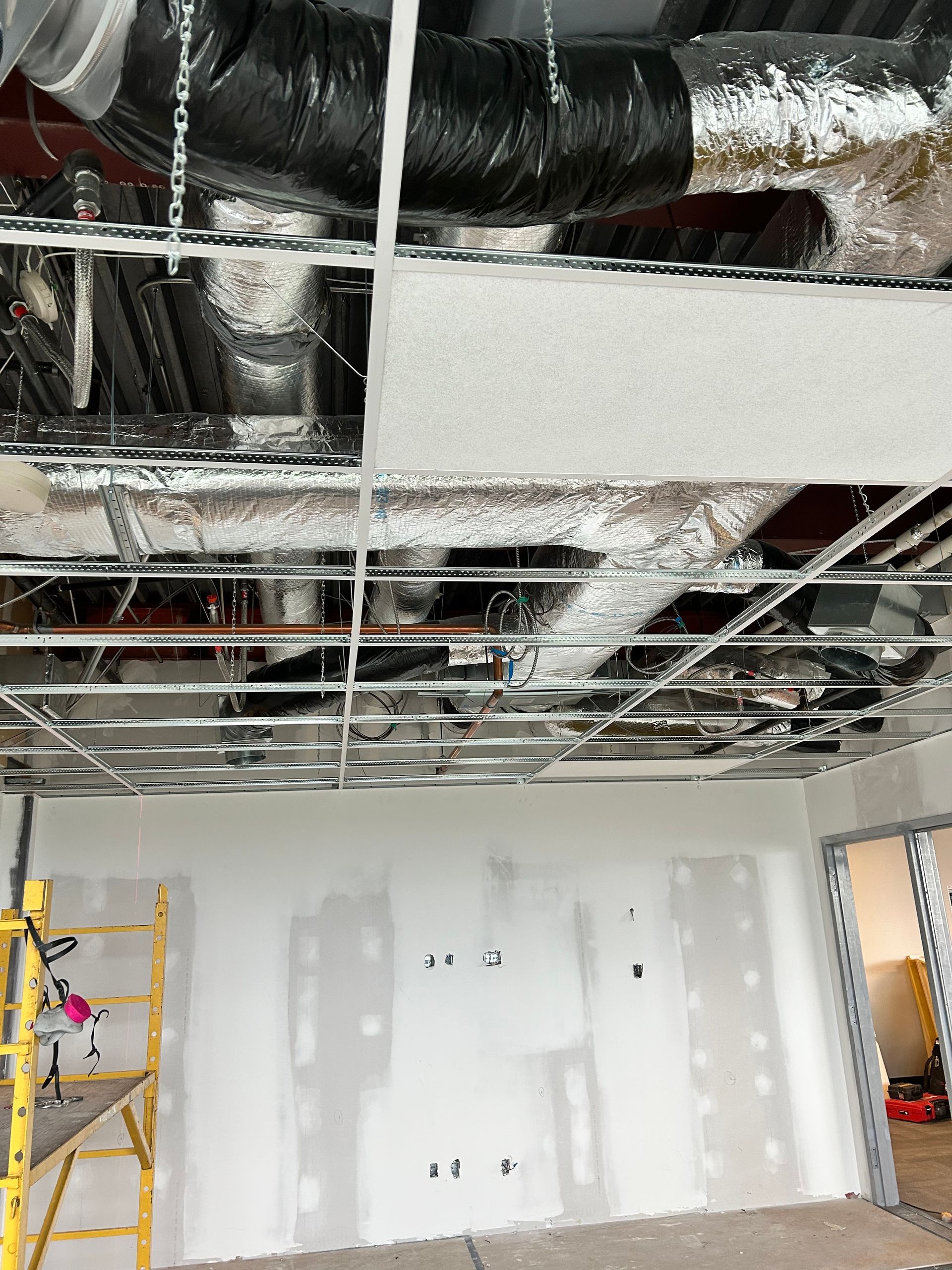 Une pièce avec un plafond auquel pendent de nombreux tuyaux.