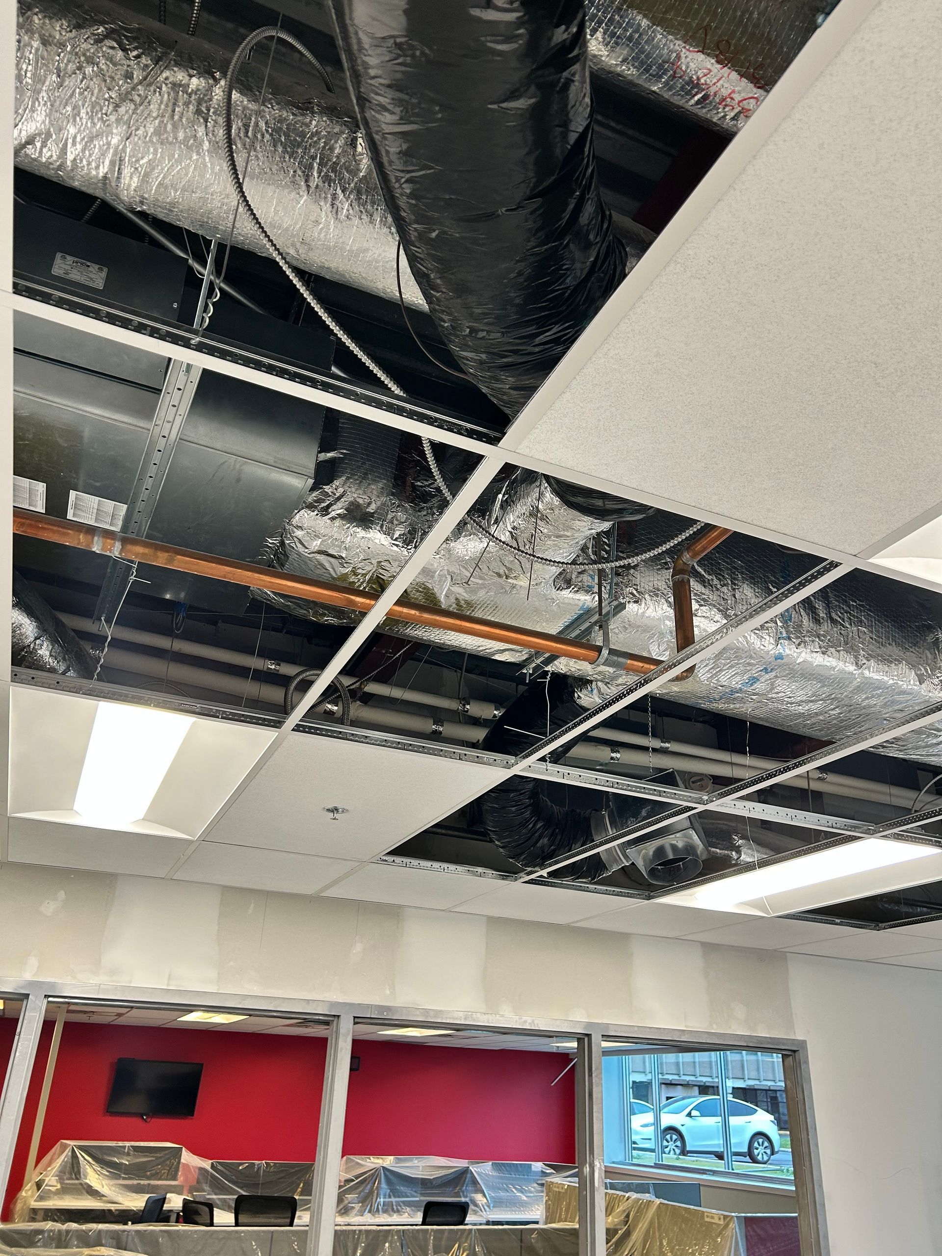 Un plafond avec beaucoup de tuyaux et de fils qui y pendent.