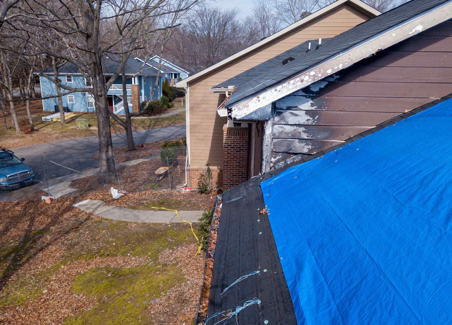 several old and worn roofs one with a tarp