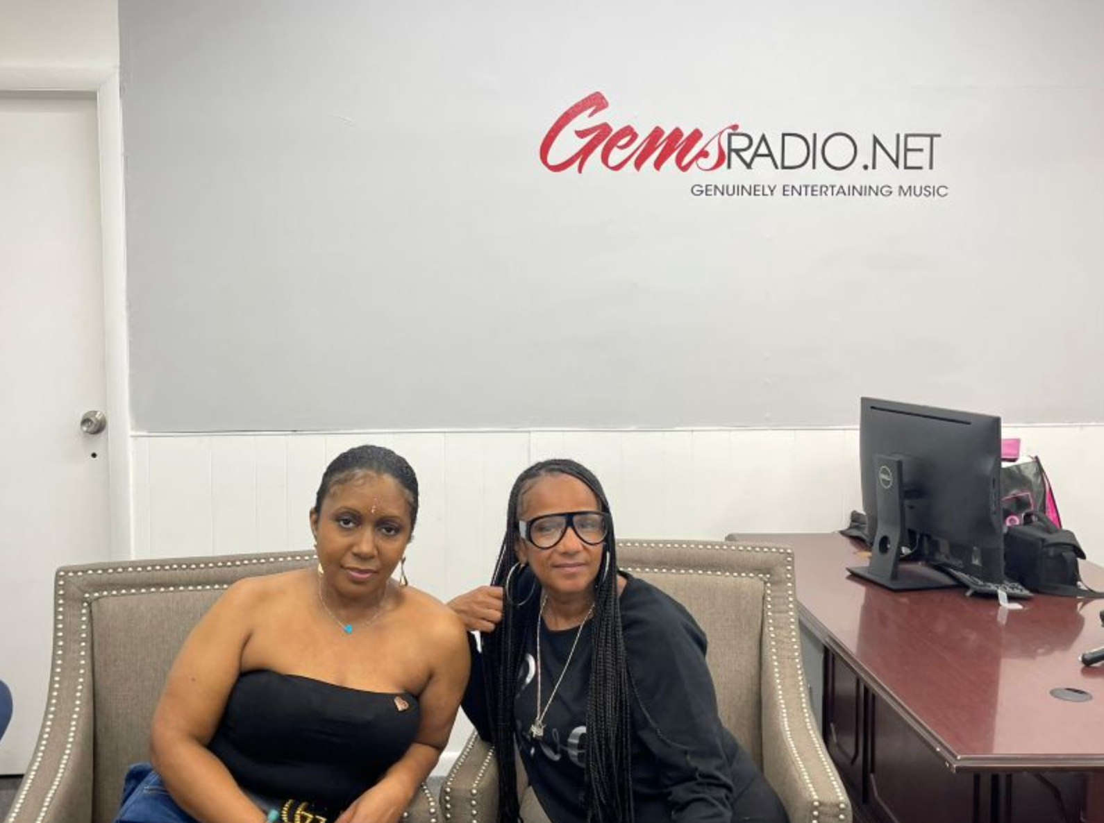 Two women seated, under a 