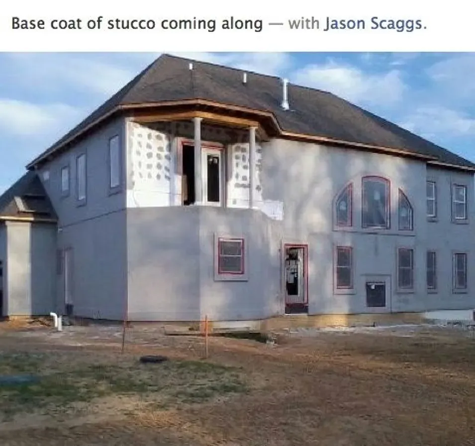 A large house is being built with a base coat of stucco coming along