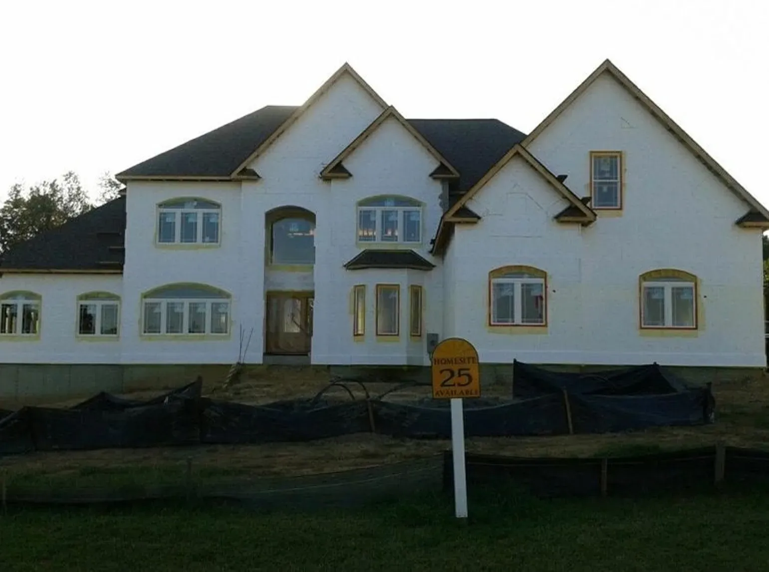 A large white house with the number 25 on a sign in front of it