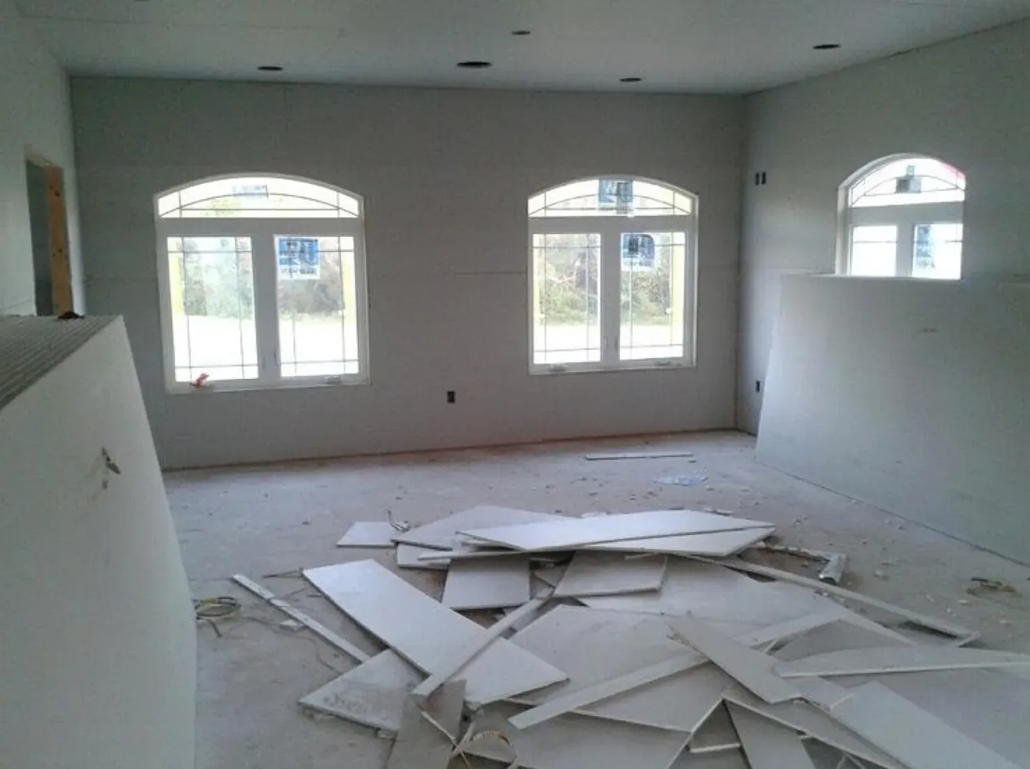 A room with a lot of pieces of drywall on the floor