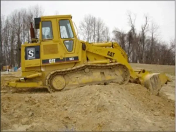 A yellow cat bulldozer is sitting in the dirt
