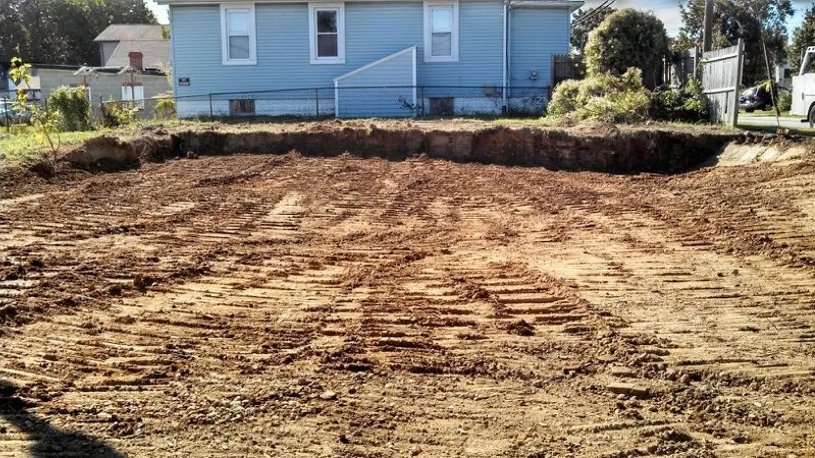 A large pile of dirt is in front of a blue house in Southern MD,
