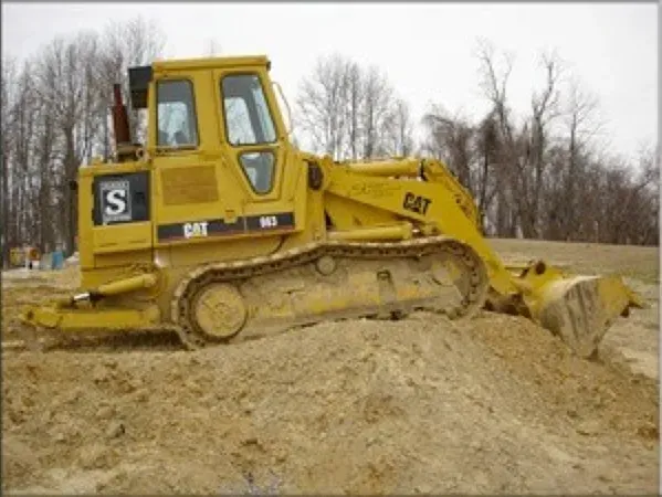 A yellow cat bulldozer is digging in the dirt