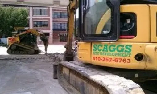 A yellow excavator with the word scaggs on it