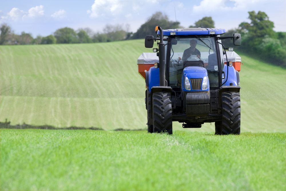 A Blue Tractor is Spraying Fertilizer on a Lush Green Field — LJE MechanicaI Gilgandra, NSW