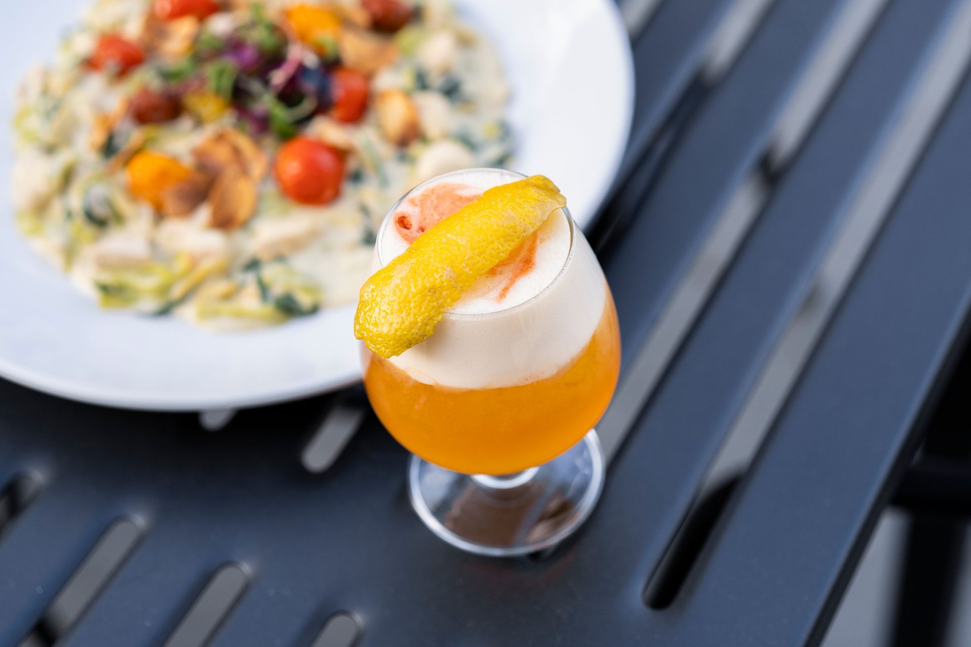 a close up of a drink on a table next to a plate of food .