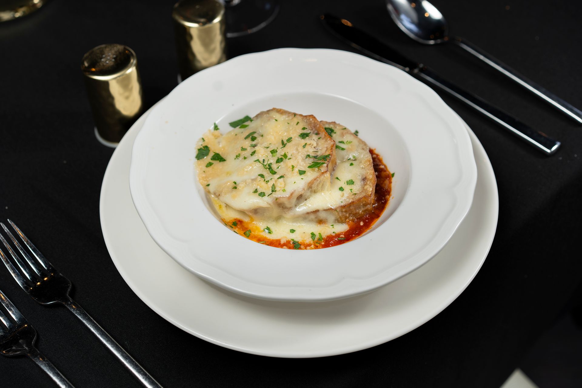 A plate of food on a table with a fork and spoon