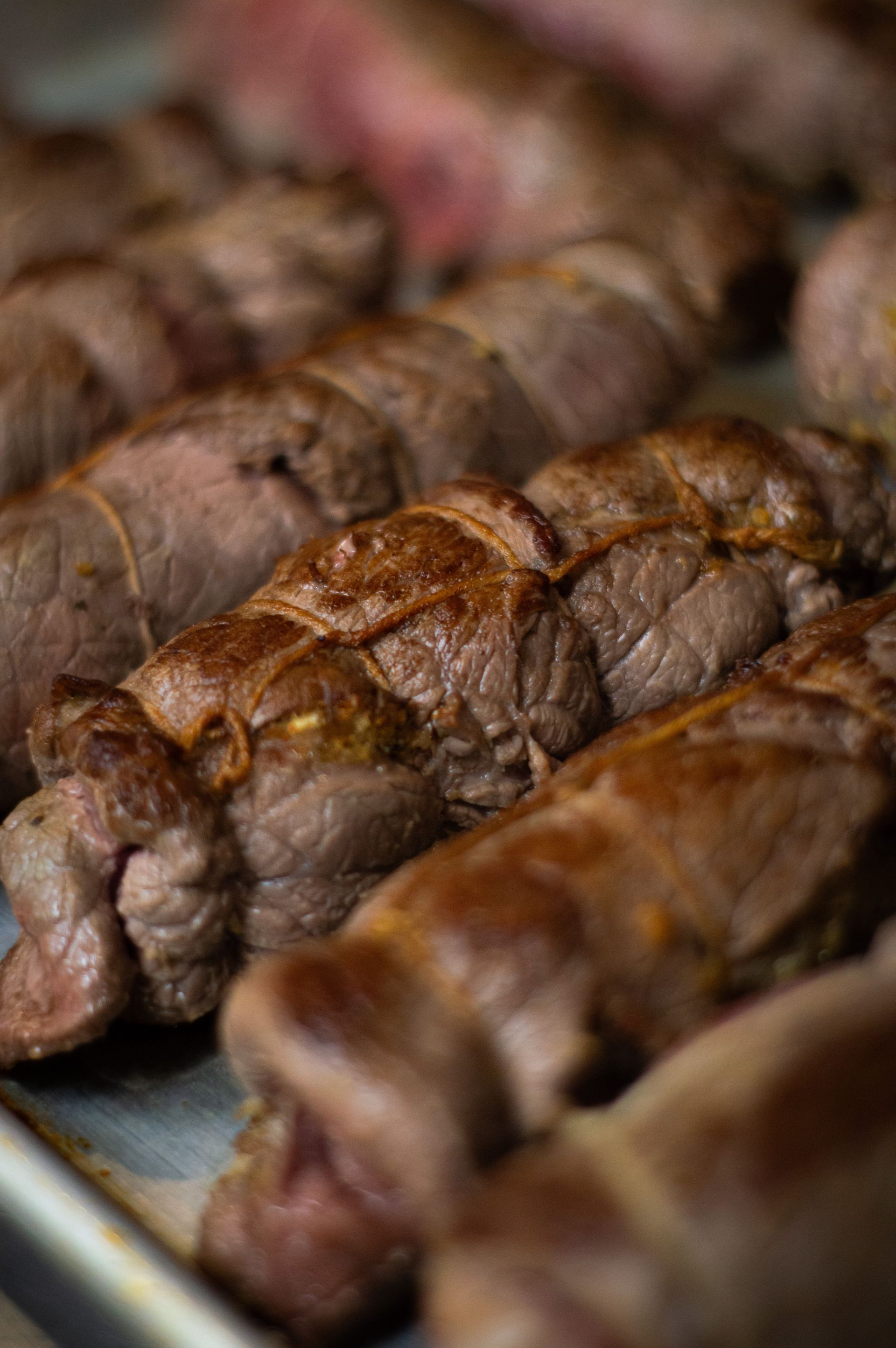 A close up of a tray of meat on a table.