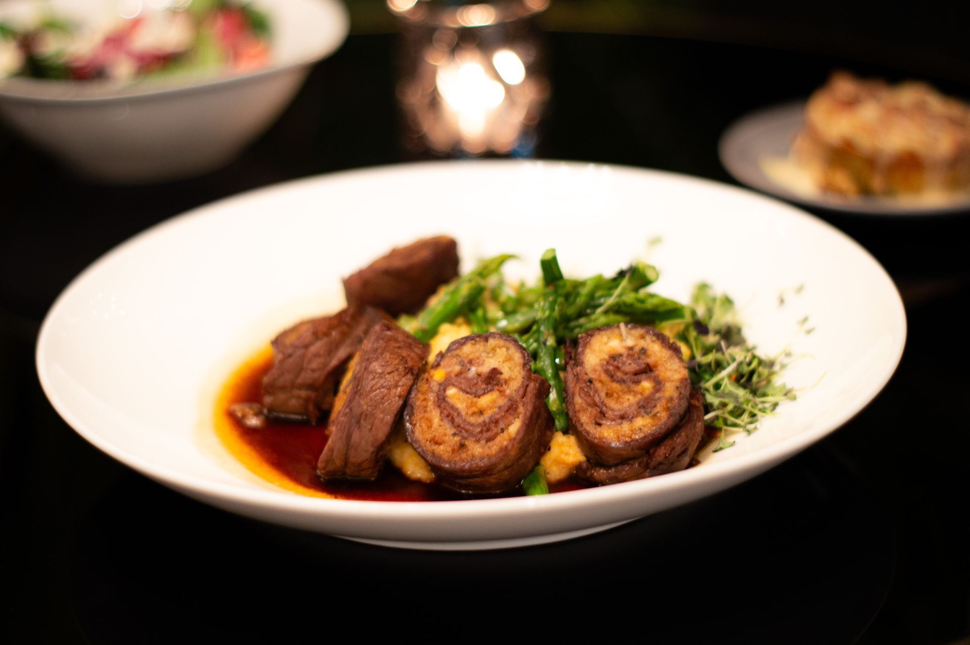 A white plate topped with meat and vegetables on a table.