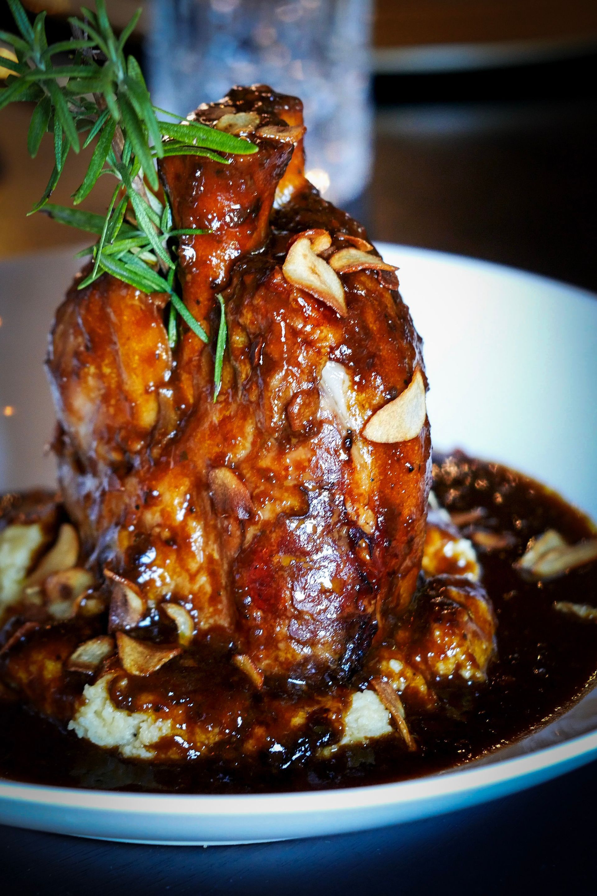 A close up of a plate of food with meat and sauce on a table.