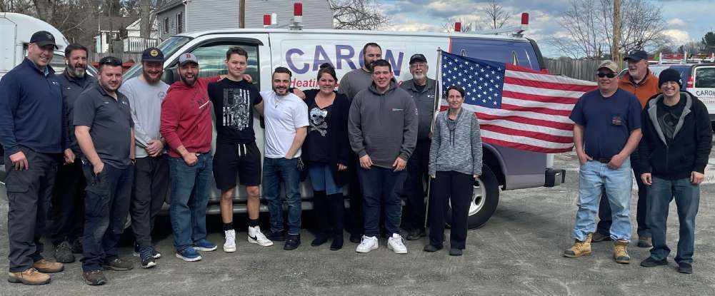 A group of people are posing for a picture in front of a van.