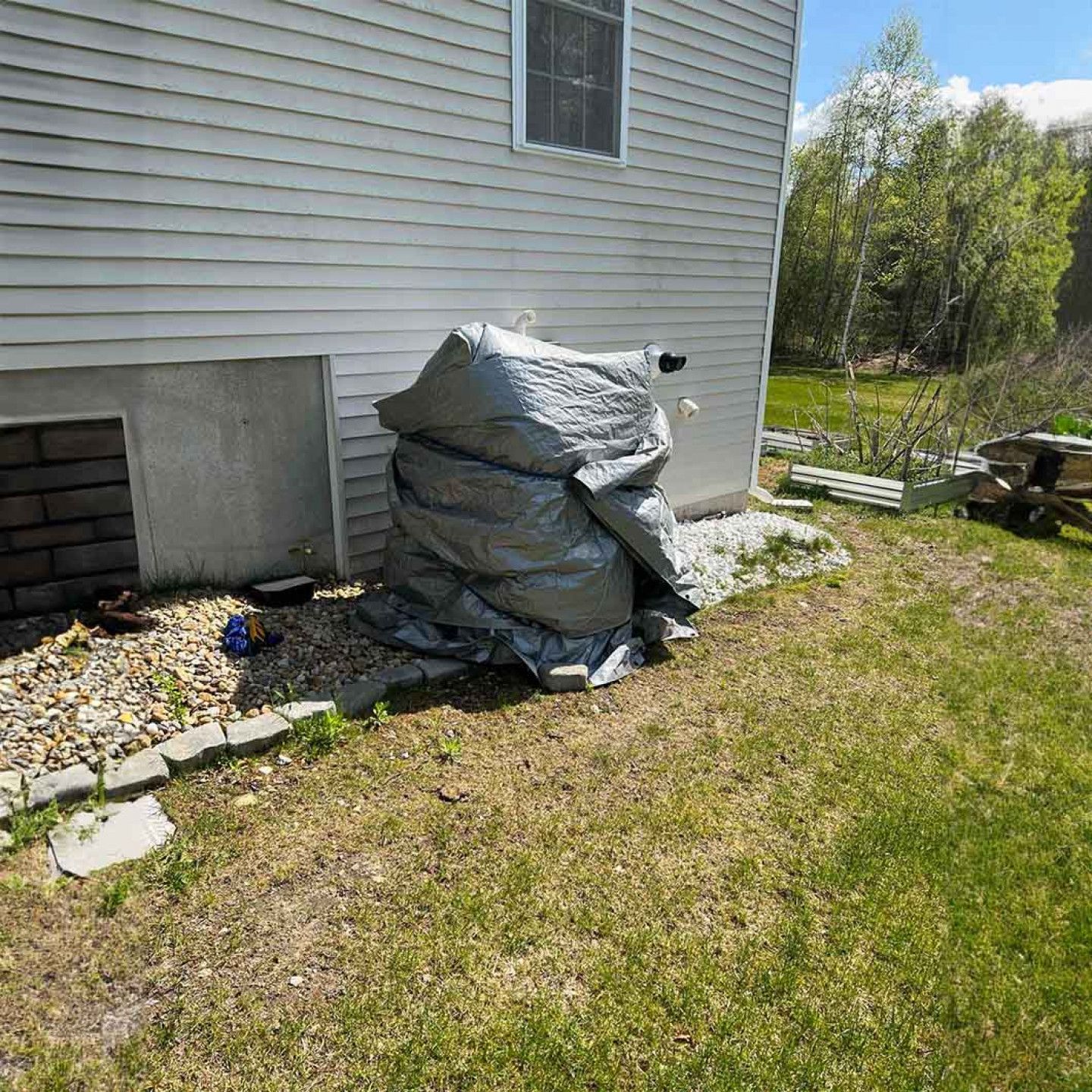 A large pile of trash is sitting in front of a house.