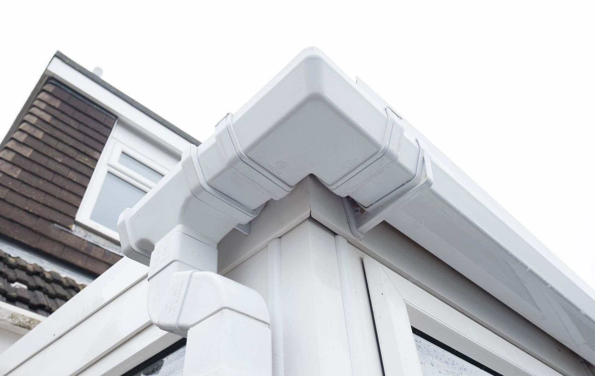 A white gutter on the side of a house