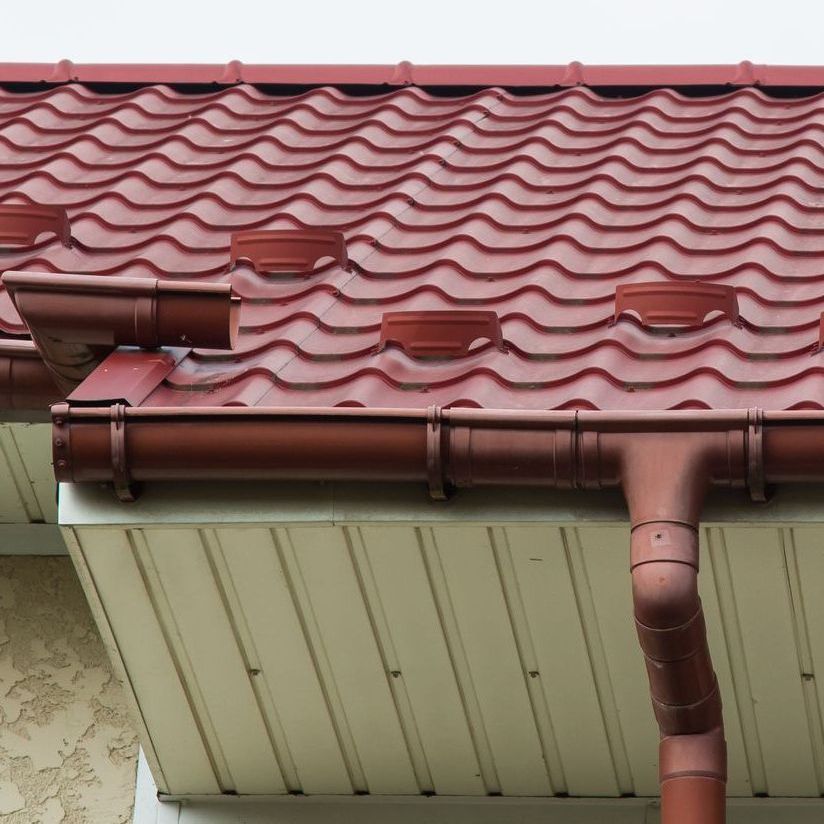 A close up of a red tile roof with gutters