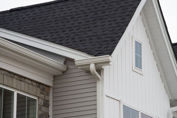 A white house with a black roof and white siding.