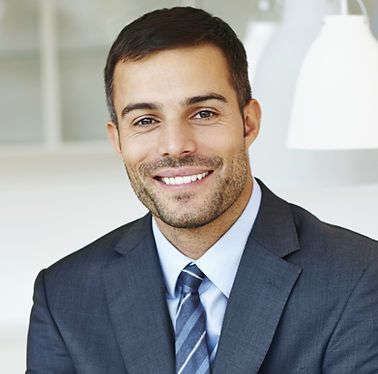 A man in a suit and tie is smiling for the camera.