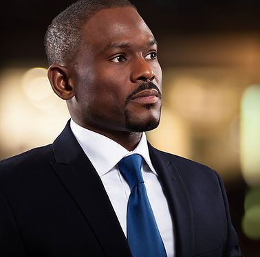 A man in a suit and tie is looking away from the camera.