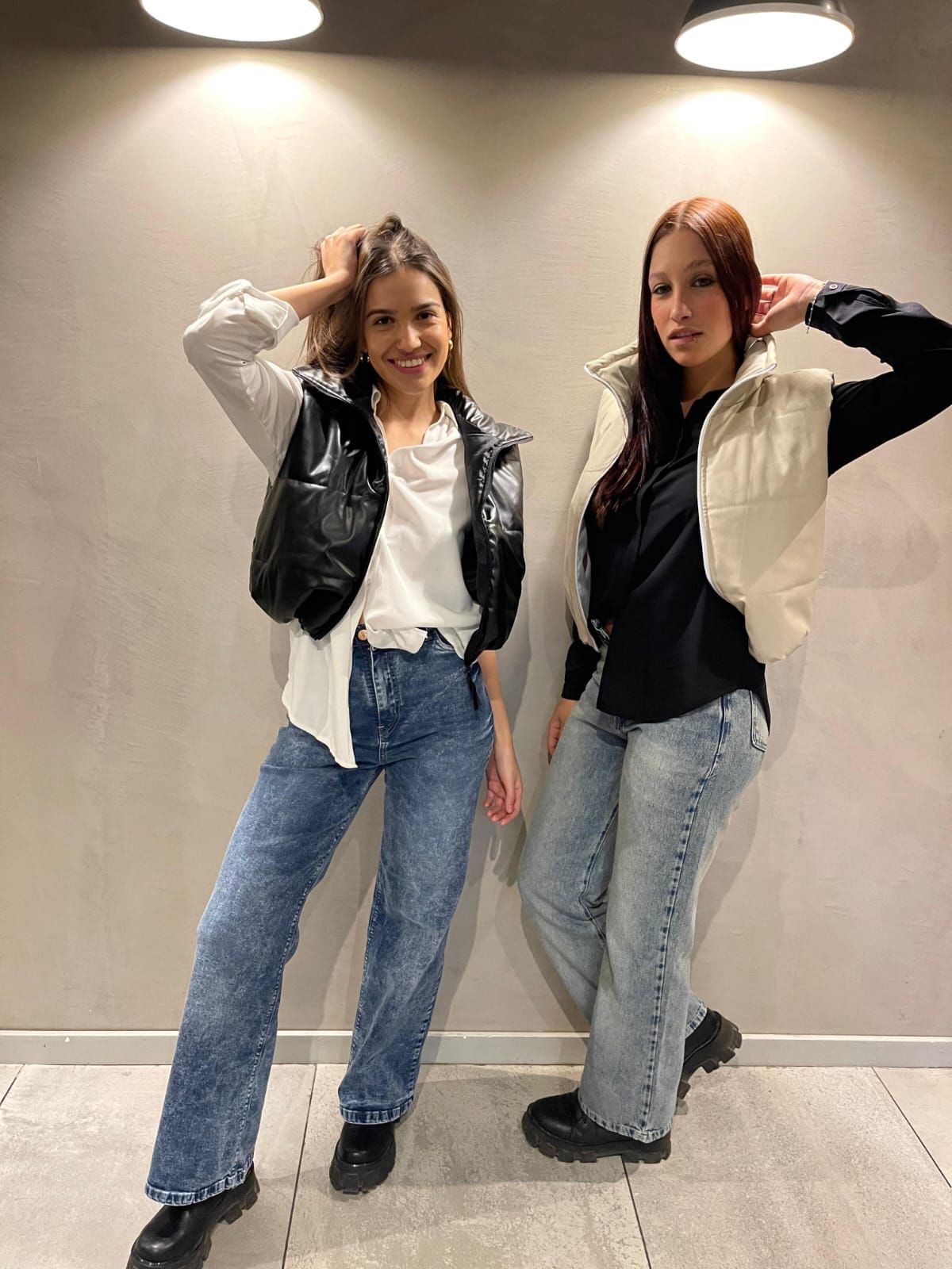 Dos personas posando en el interior, bajo las luces del techo