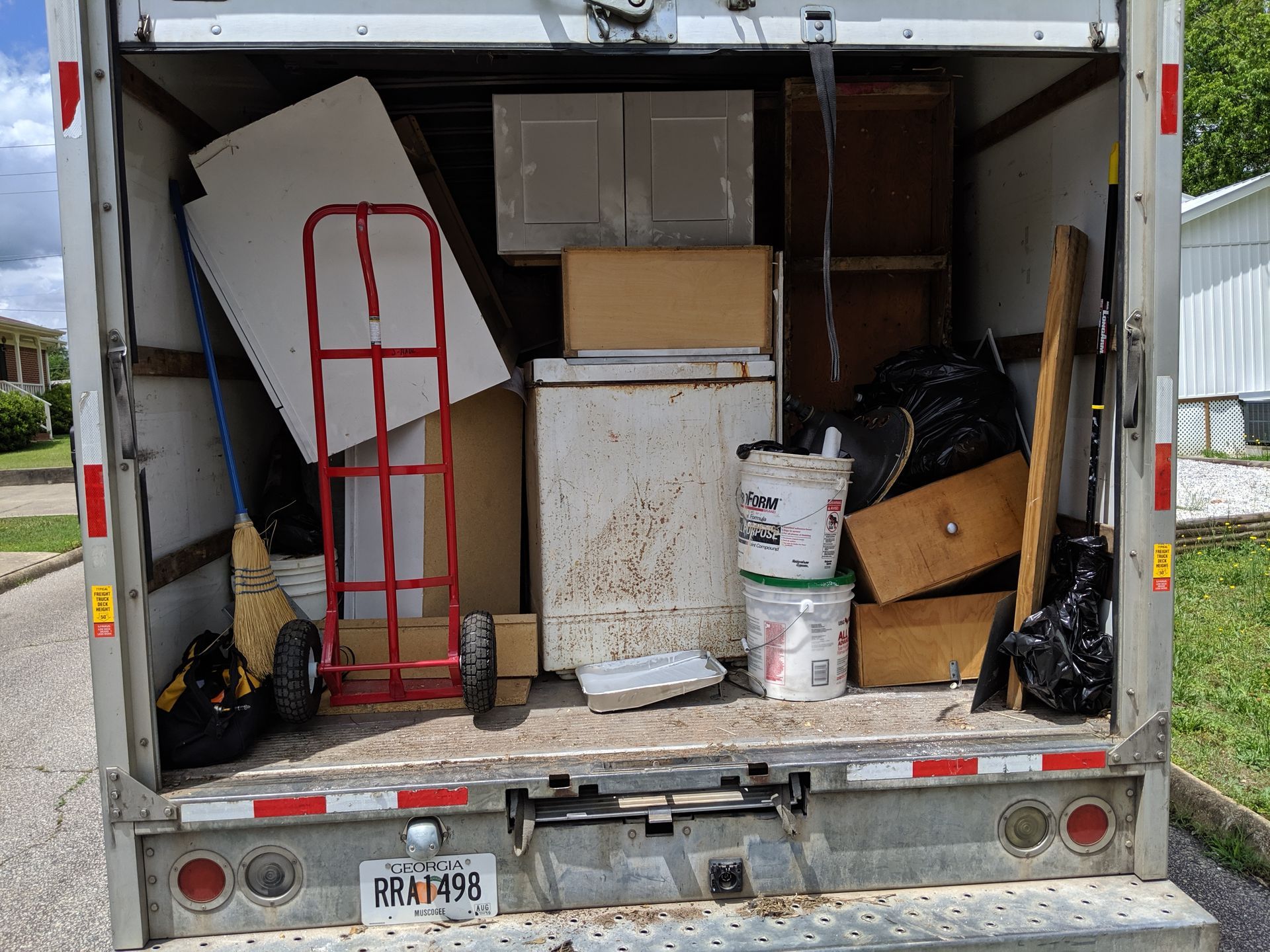 A pile of wood is sitting in front of a dumpster.
