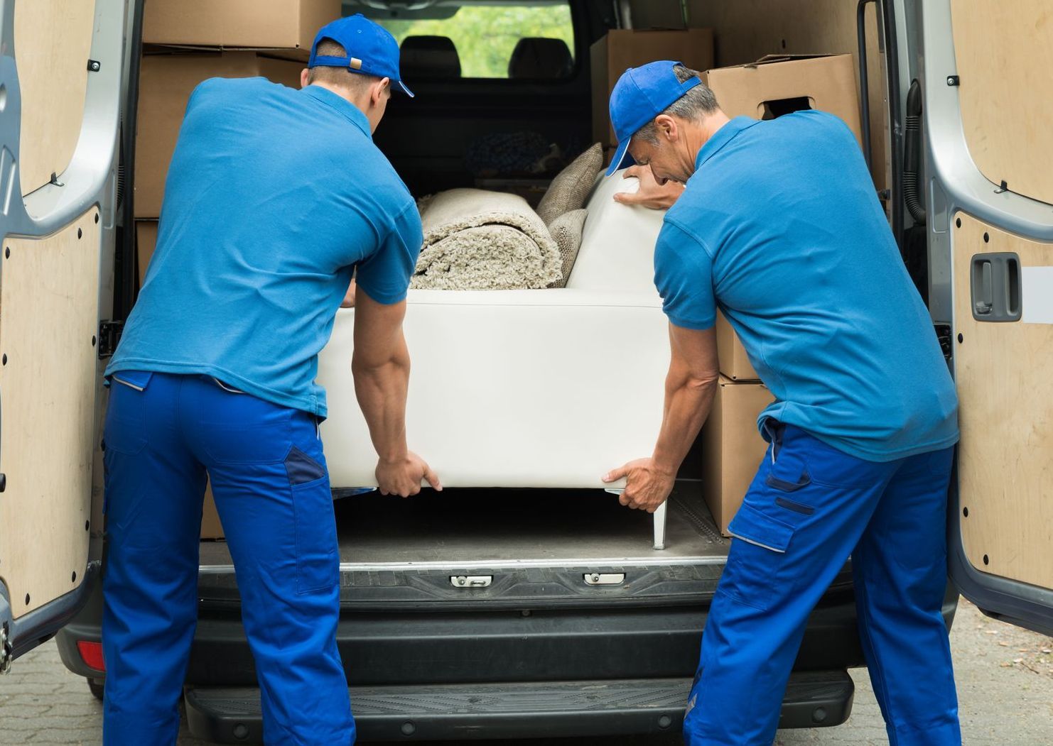 A pile of junk is sitting on the grass next to a sidewalk.