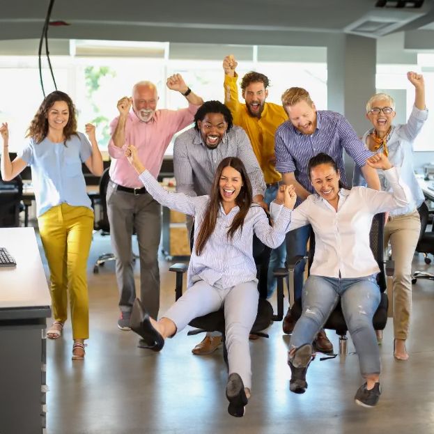 A group of people are posing for a picture with their arms in the air.
