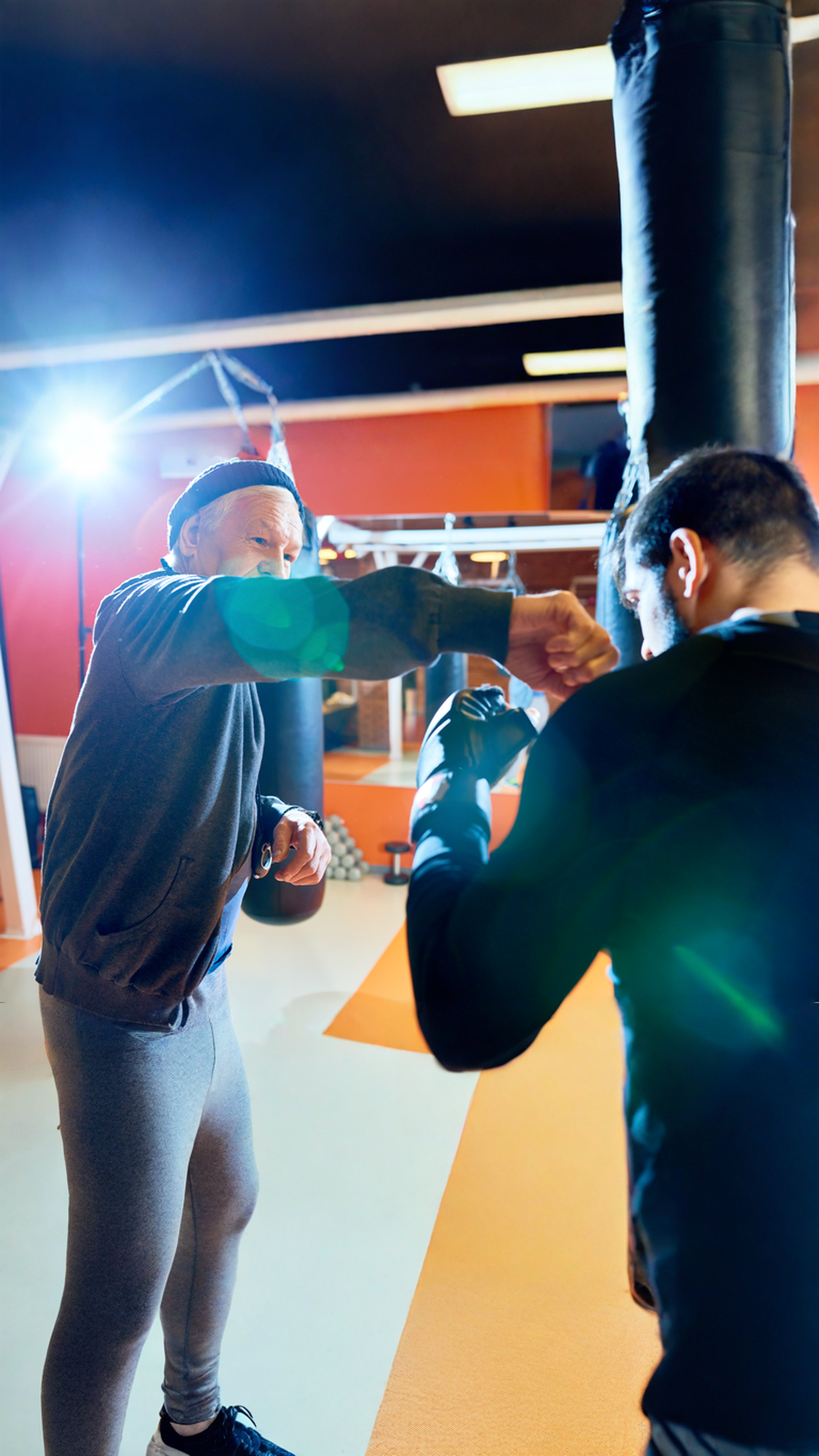 A man and a woman are practicing self defense in a gym.