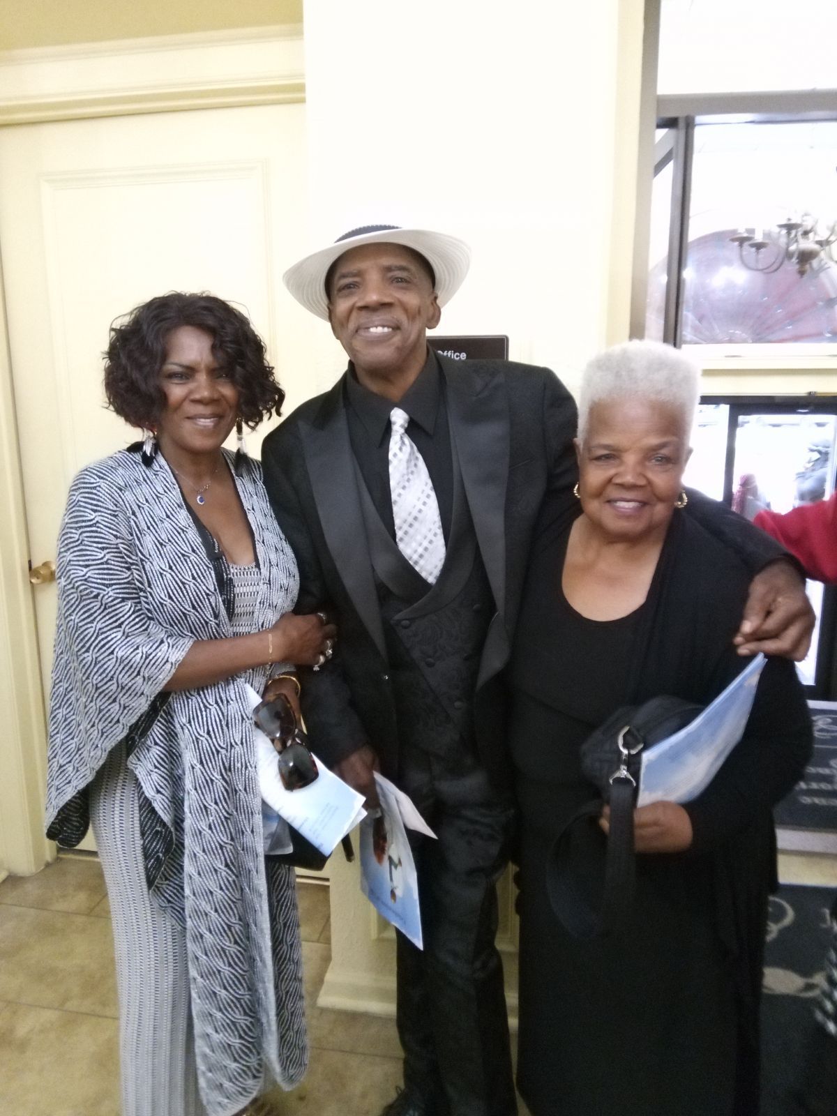 A man in a tuxedo is posing for a picture with two women