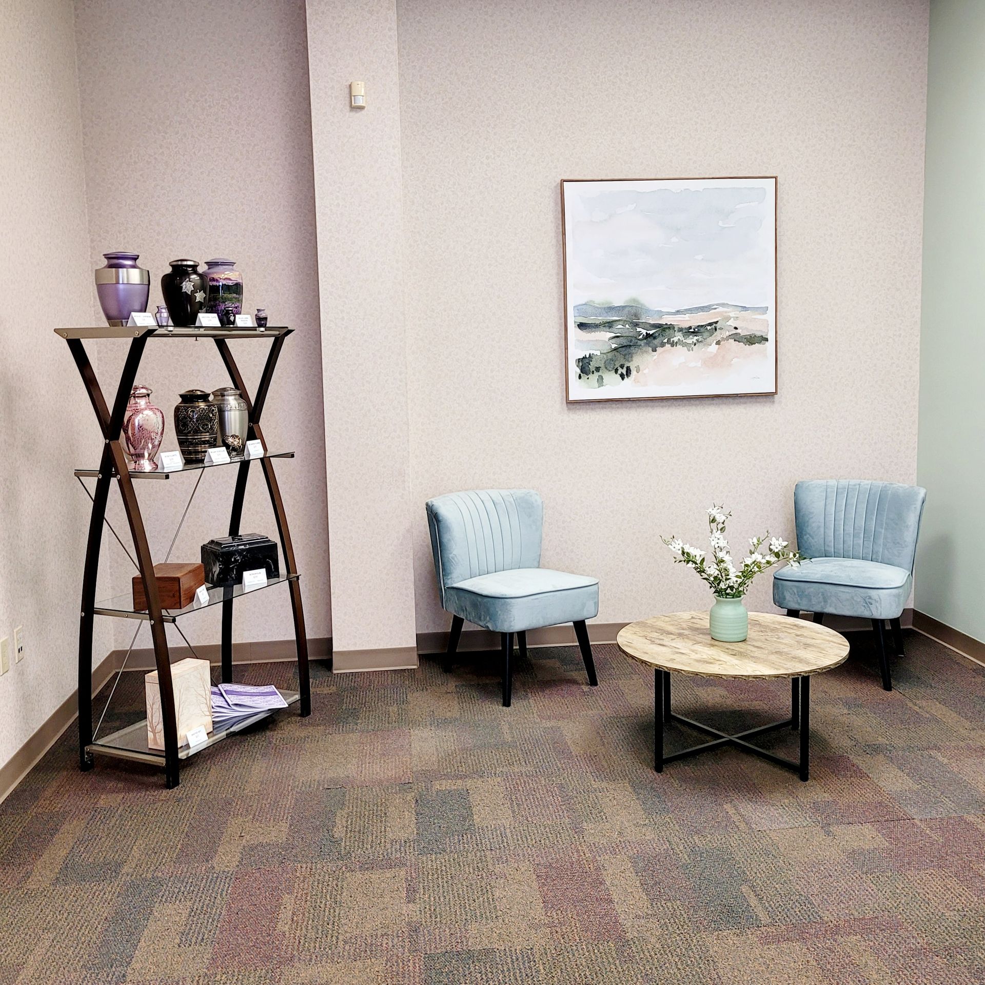 a living room with a table and chairs and a painting on the wall