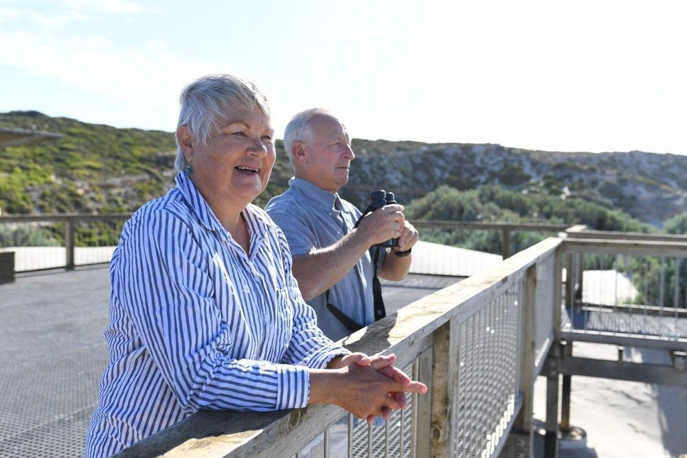 An aerial view of a boat in the water near a cliff
