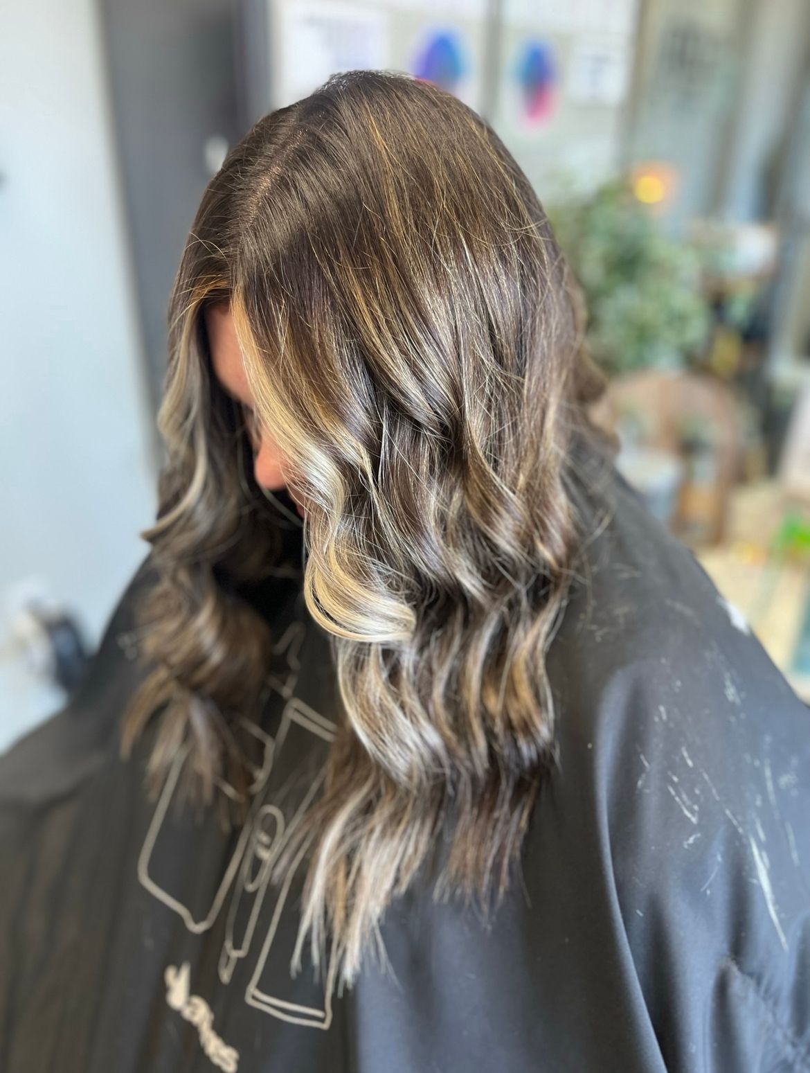 A woman with long brown hair is wearing a black cape.