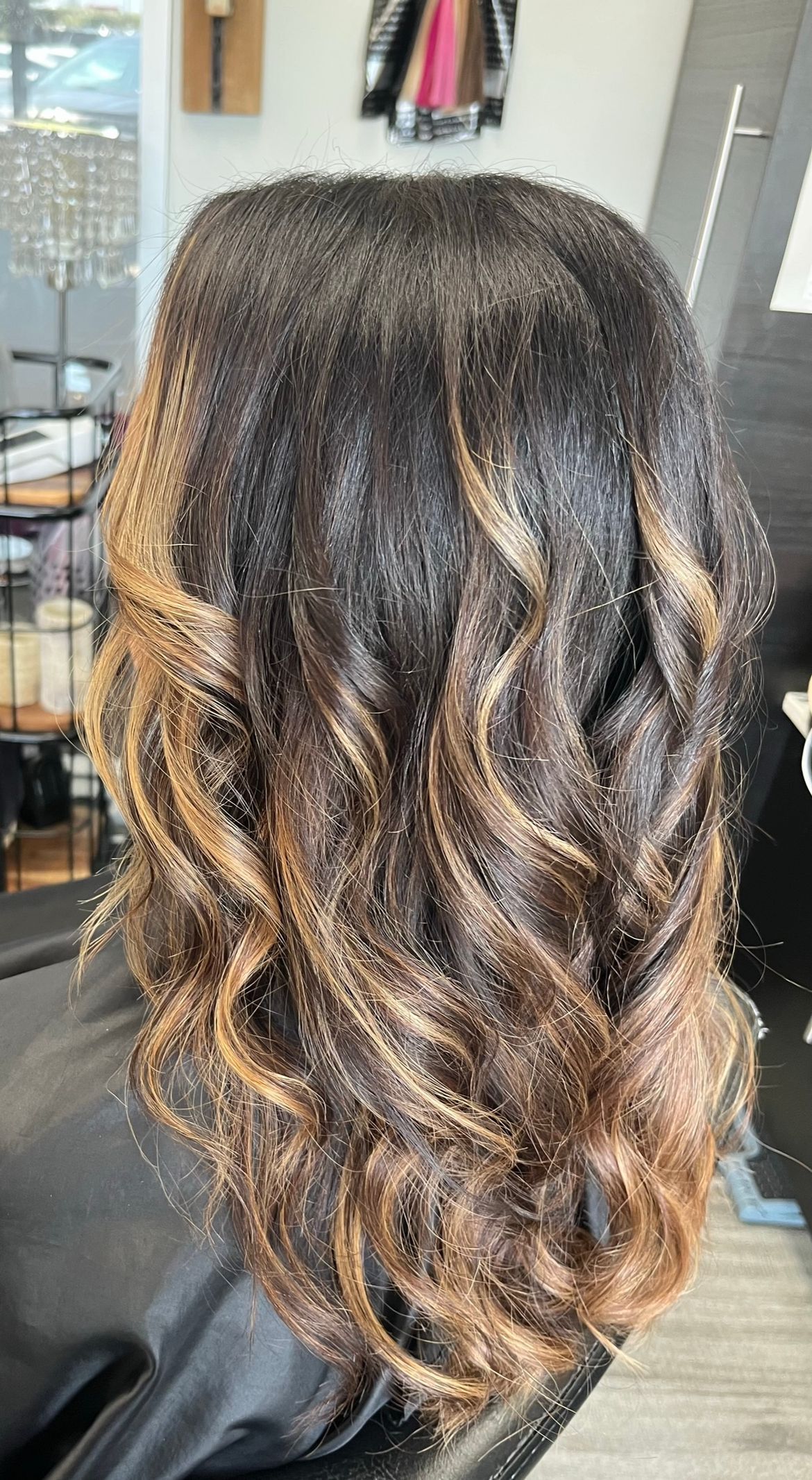 A woman is sitting in a chair with her hair in a bun.