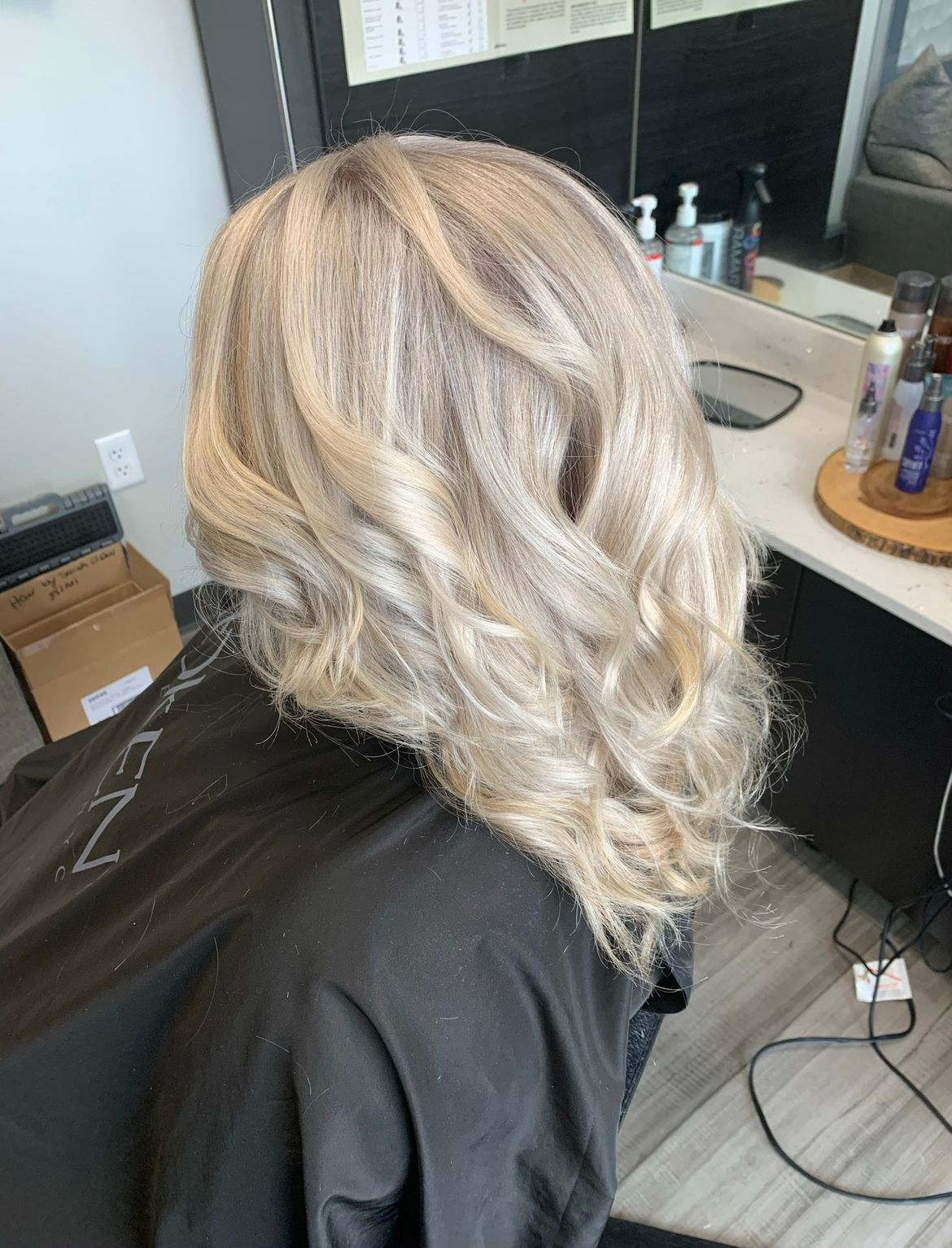 A woman with red hair is sitting in a chair in a salon.