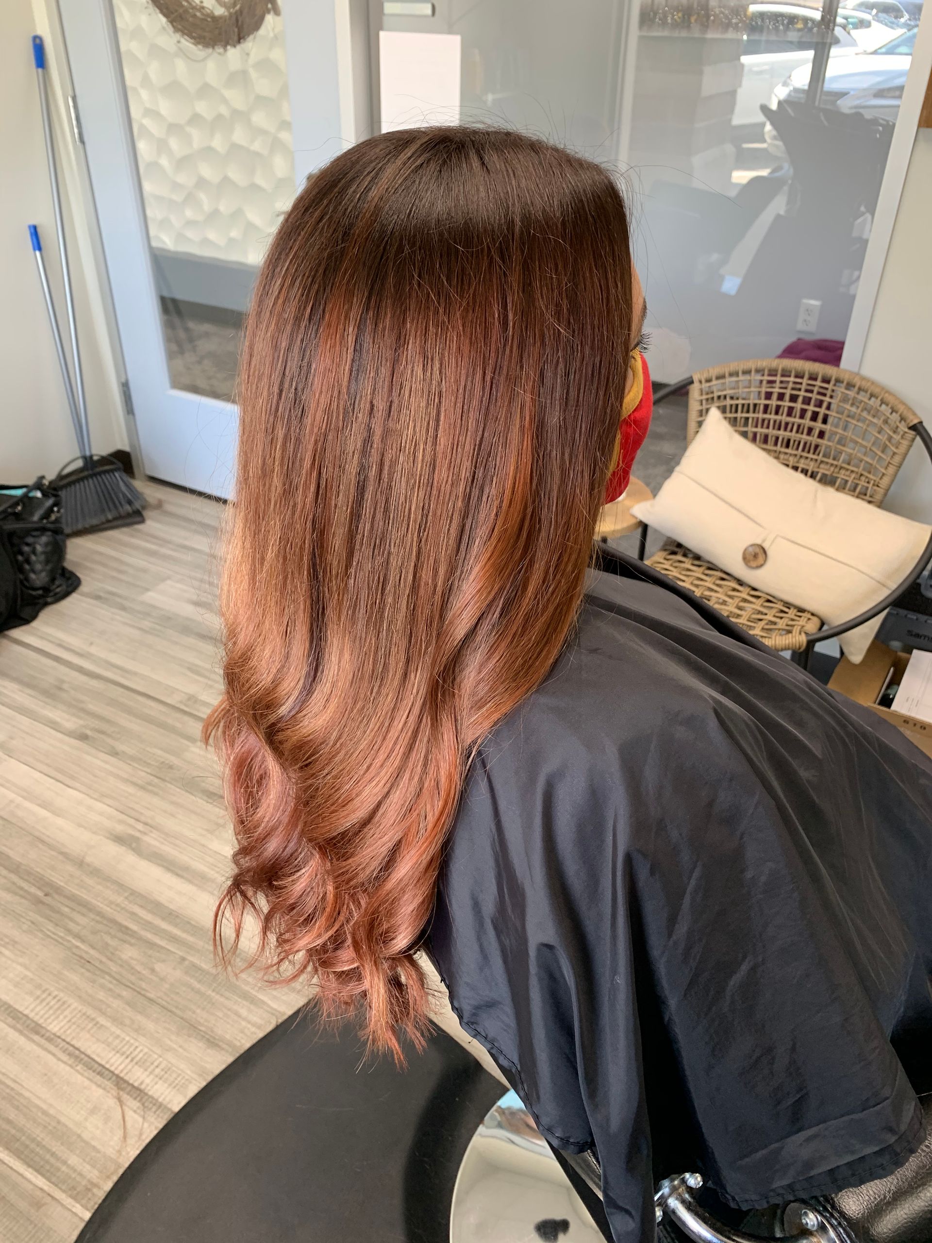 A woman with long hair is sitting in a chair in a salon.