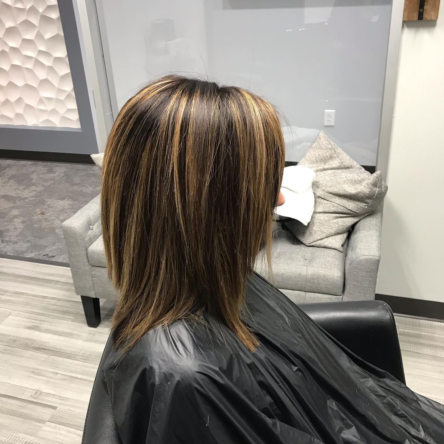 A woman is getting her hair cut in a salon.
