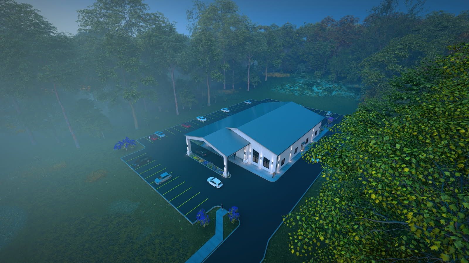 Building with a parking lot surrounded by trees, in a foggy setting.