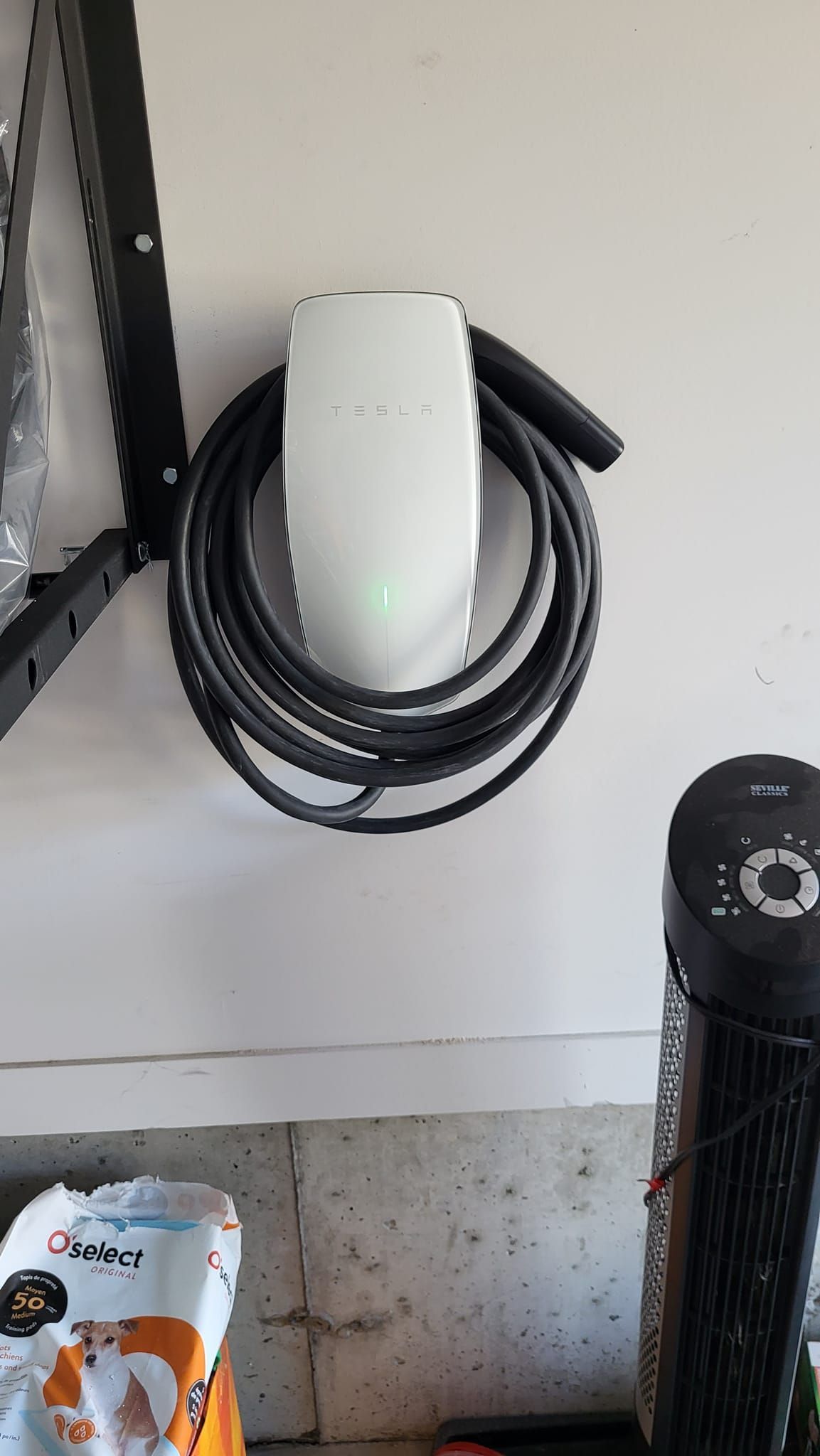 une station de recharge Tesla est accrochée au mur d un garage.