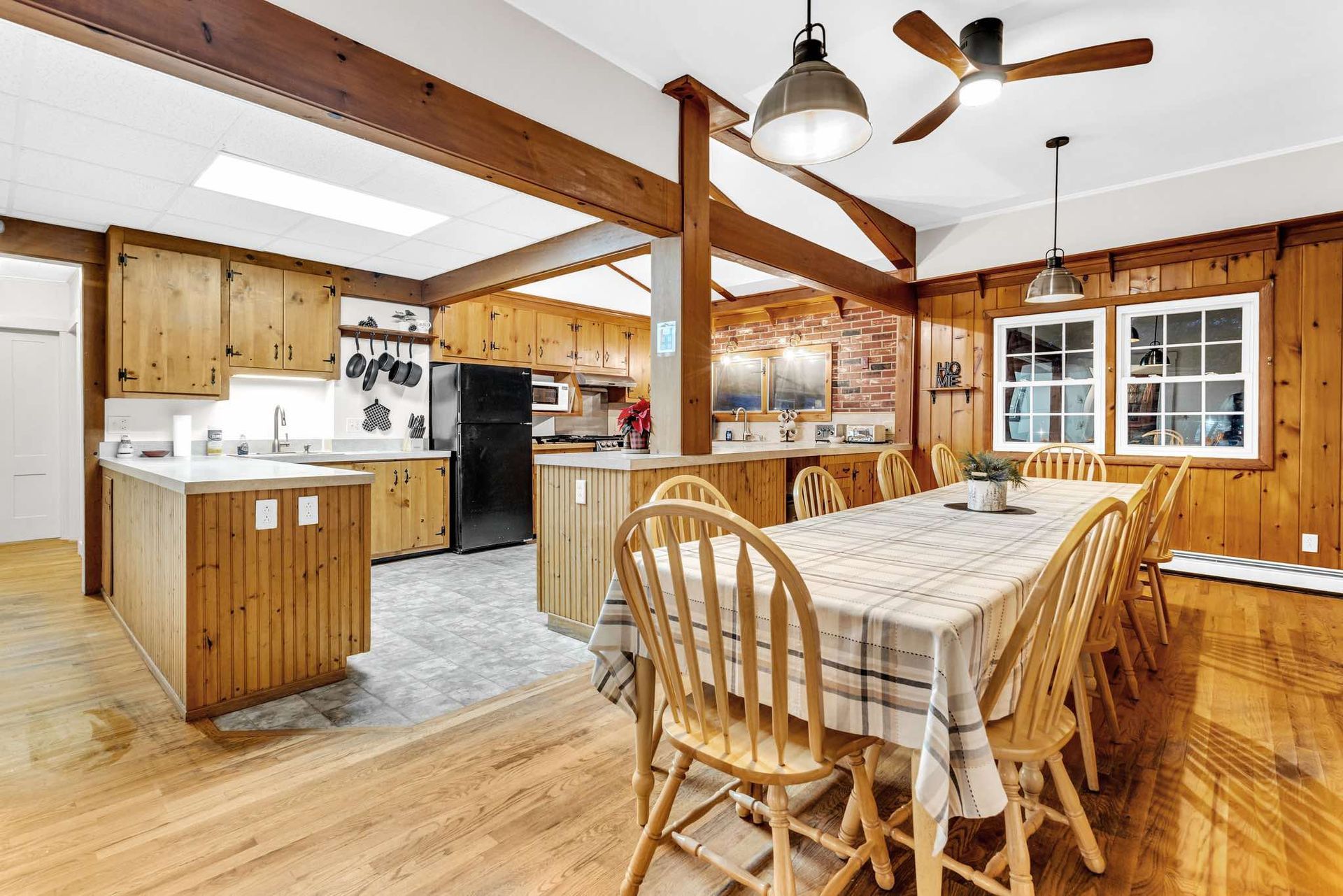 Spacious rustic kitchen and dining area with wood paneling, dining table, and island.