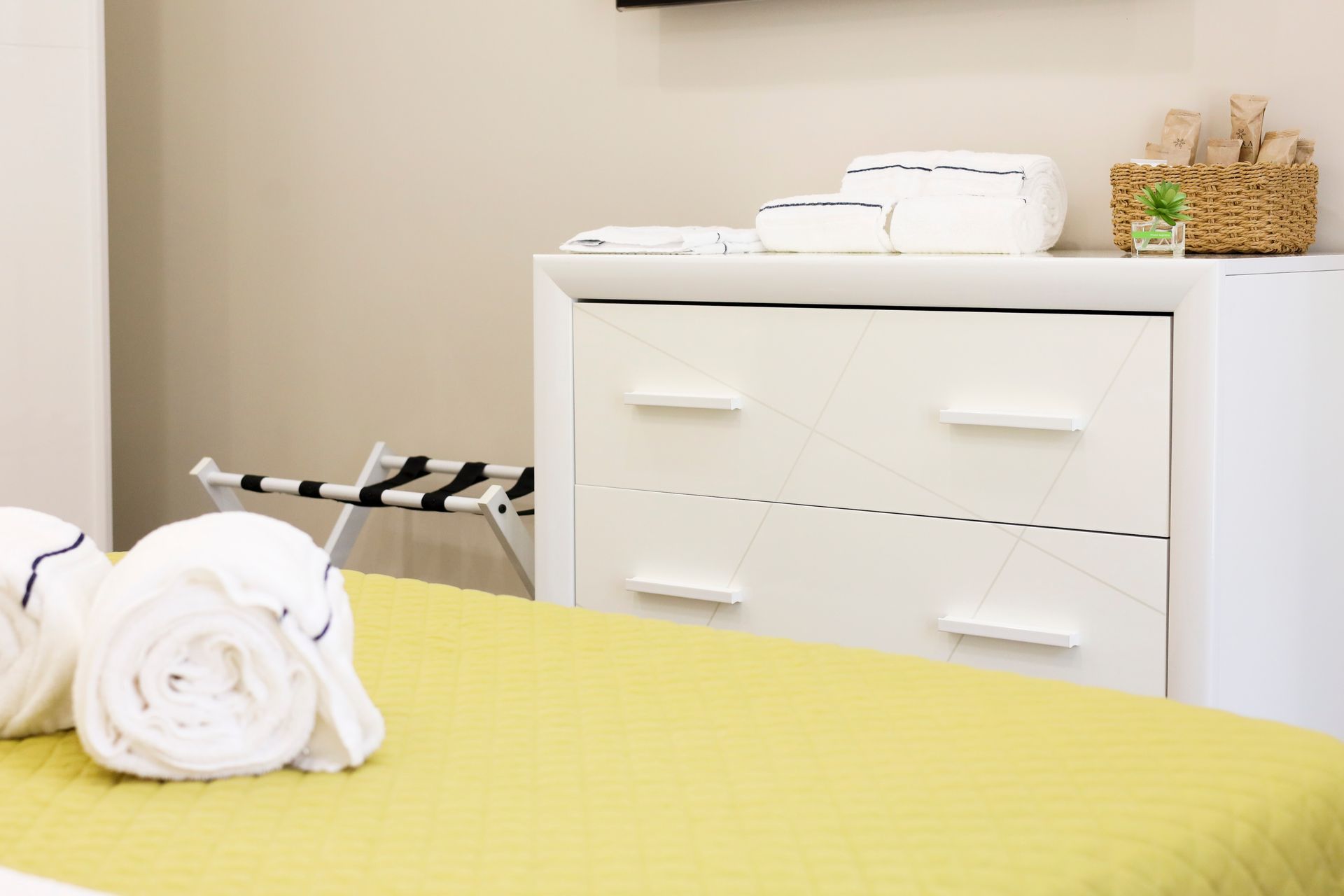Bedroom with a bed, a dresser, and towels on the bed.
