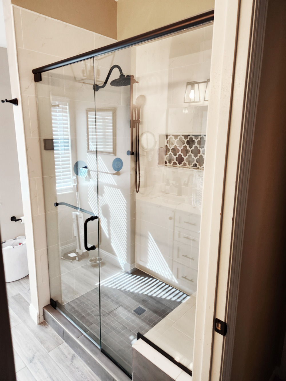 Celesta Door and Panel Enclosure with Header with Clear glass and a Matte Black metal finish.