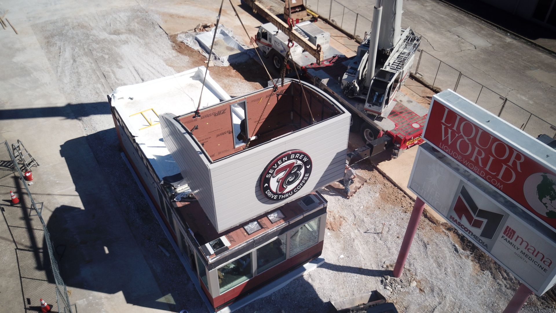 A crane lifts a building section with a 